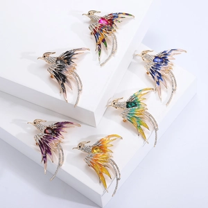 Detailed overhead shot of six enamel phoenix brooches with rhinestones in various colors