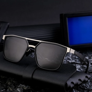 Polarized sunglasses with black frame and silver bridge on leather case and rock base