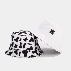 Detail of cow print and white bucket hats with smiley patch and durable stitching
