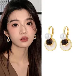 Detailed close-up and model view of vintage gold plated tiger eye stone drop earrings