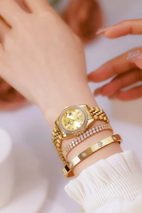 Close-up of a gold quartz watch with rhinestones and matching screw-motif bracelets