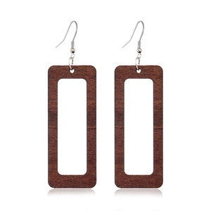 Detail of dark brown hollow wooden rectangular earrings with natural grain and metal hooks