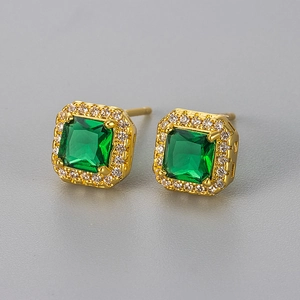 Macro shot of square emerald green stone earrings with white zircon halo in gold plating