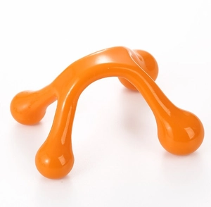 Close-up of an ergonomic orange four-leg manual massager tool for pressure point relief