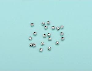 Macro shot of silver S925 sterling silver triangle beads on a turquoise background