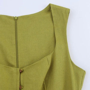 Close-up of green linen dress showing wood buttons and back zipper detail