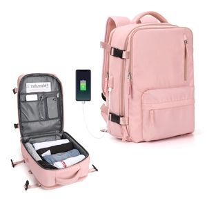 Pink travel backpack detail showing large capacity open compartment and USB charging port