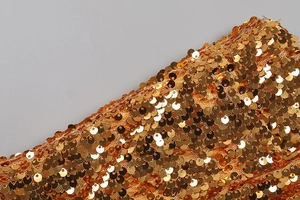Gros plan détaillé de paillettes dorées sur le tissu d'une robe bustier sexy et slim