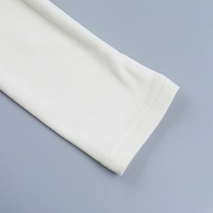 Détail de haut blanc ajusté montrant le tissu en maille fine et les finitions de couture