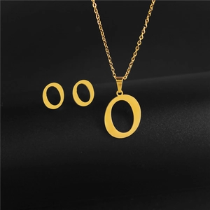 Detailed view of golden capital letter O pendant necklace and matching stud earrings set