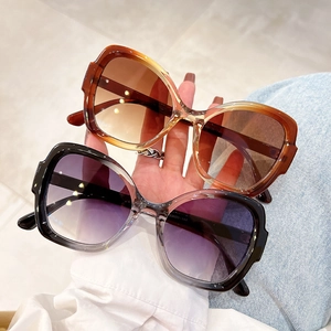 Close-up of amber brown gradient lenses and tortoise frame on butterfly sunglasses