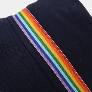 Close-up of navy blue cotton bucket hat featuring rainbow striped ribbon and stitching