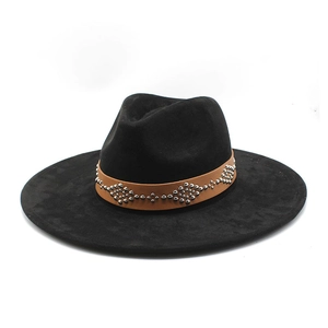 Detail of black wide brim cowboy hat with studded brown leather band and geometric metal studs