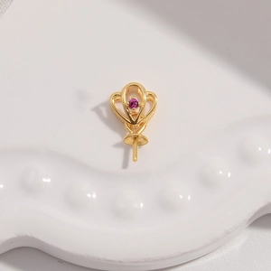 Macro view of a gold-plated heart-shaped pendant bail with a purple gemstone and needle pin