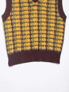 Close-up of yellow textured knit vest with purple plaid pattern and ribbed hem detail