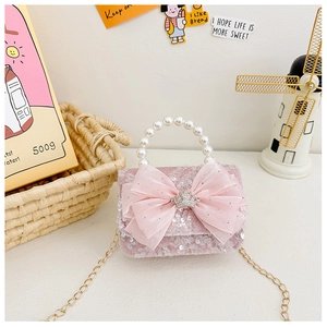 Detail of pink sequin girls handbag with lace bow, crown accent and pearl handle