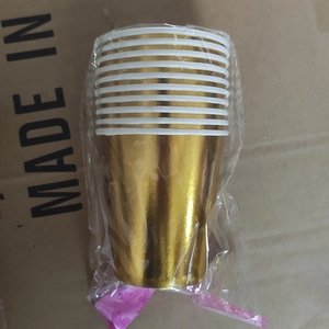 Detail of disposable gold paper cups packed in sealed plastic bags for party supplies