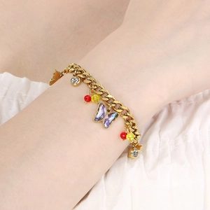 Detail of gold chain bracelet with purple butterfly charm and colorful beads on wrist