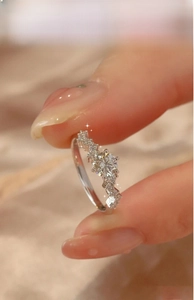Close-up of a luxury moissanite ring with a brilliant round main stone and side diamonds