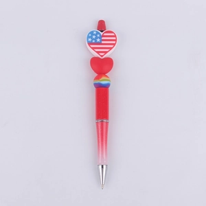 Detail of red beadable pen with USA flag heart topper and rainbow bead accents
