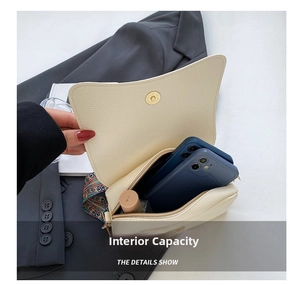Detail showing internal capacity of the cream leather bag with phones and lipstick