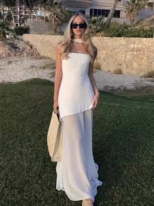 Outdoor model wearing white halter neck maxi dress with an asymmetrical mesh hemline detail