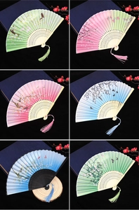 Detailed close-up of colorful folding fans with silk patterns and elegant tassels