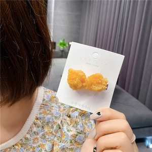 Close-up of a creative fried chicken hair clip with realistic golden crispy texture