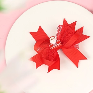 Detailed view of red Christmas bow clip with Merry Christmas tag on white display