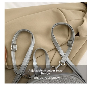 Detail of adjustable gray leather strap with silver buckle and studs on stylish backpack