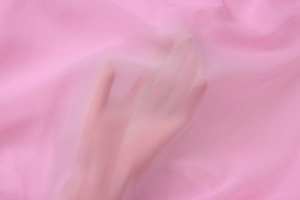 Detail of sheer pink mesh fabric showing delicate pleated texture and transparency