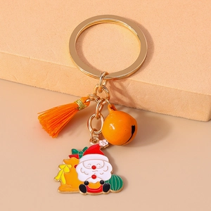 Close-up of a Santa Claus keychain with an orange bell and tassel on a golden ring