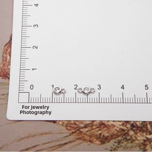 Close-up detail of 925 sterling silver cubic zirconia charms on a measurement ruler