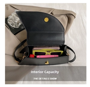 Internal capacity of the black saddle bag showing phone, sunglasses, and lipstick
