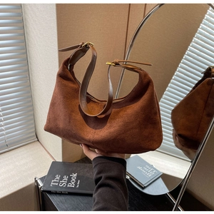 Detail of brown frosted leather hobo bag with adjustable gold buckle and suede texture