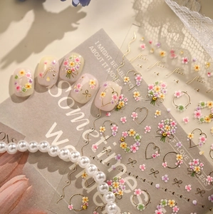 Detail of French floral nail stickers with 3D gold embossed flowers and bow designs