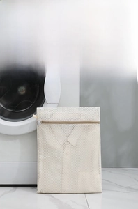 Durable honeycomb mesh laundry bag with gold zipper protect a white shirt inside