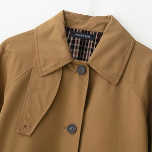 Fashionable tan trench coat with classic plaid lining and lapel detail on white background
