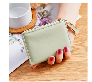 Close-up of light green PU leather wallet with gold zipper and stylish tassel detail