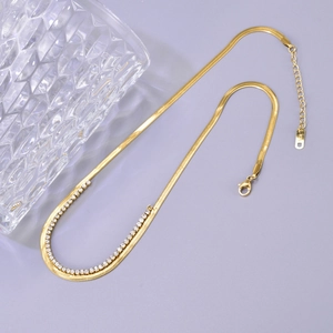 Detail of gold-plated herringbone and cubic zirconia layered chain with lobster clasp