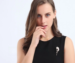 Elegant calla lily brooch with white enamel petals on a black sleeveless top