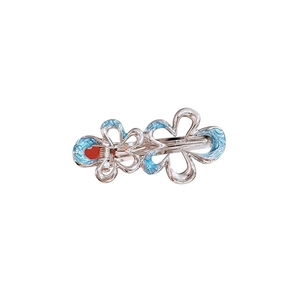 Silver flower hair clip with blue enamel accents on minimalist metal star-shaped base