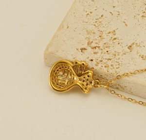 Dettaglio macro della collana con pendente sacchetto portafortuna placcato oro 18k