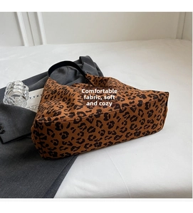 Close-up of leopard print hobo tote bag texture on white cloth with soft lighting