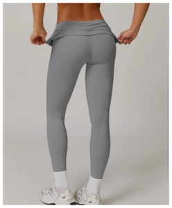 Close-up of the skirt-style layering on high-waist yoga leggings in dark gray fabric