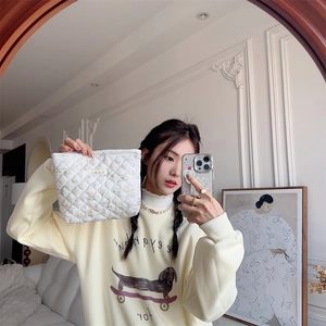 Close-up of quilted cosmetic bag featuring floral patterns and cute rabbit prints