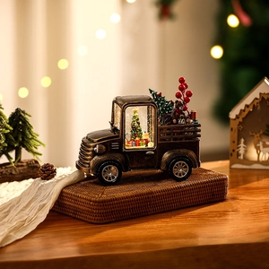 Close-up of vintage bronze Christmas truck with glowing LED water globe and festive decor