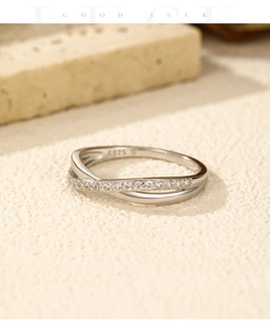 Macro shot of S925 sterling silver crisscross ring with small clear gemstones on band