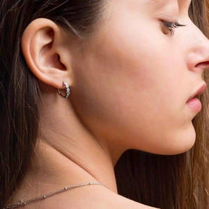 Close-up of S925 silver earrings with light blue turquoise stones worn by a model
