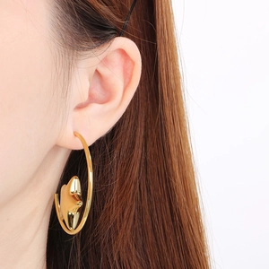 Macro shot of 18k gold plated stainless steel C-shaped hoop earring with a star pendant